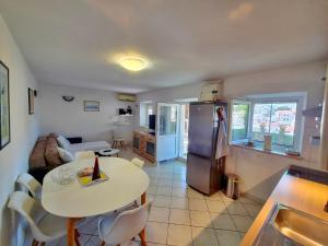 a kitchen and living room with a table and a refrigerator at House Zarko in Pučišća