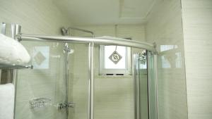 a shower with a glass door in a bathroom at Amdina Hotel in Mekʼelē