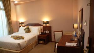 a hotel room with a bed and a desk at Amdina Hotel in Mekʼelē