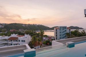 a view of the city from the balcony of a building at EOS Suites in Santa Cruz Huatulco