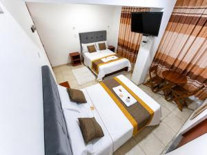 a bedroom with two beds and a tv in it at Hotel World Peru in Lima