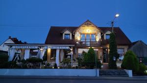 a house with lights on the front of it at Apartament Nad Lodziarnią in Wydminy