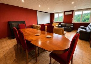 a conference room with a wooden table and chairs at Ciné Lodge Lourdes in Lourdes +18 photos