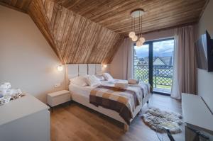 a bedroom with a large bed and a large window at Stacja Tatry in Poronin