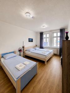 two beds in a room with wooden floors at Kael Apartment in Teplice