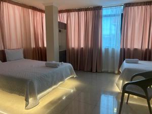 a bedroom with a bed and a window with curtains at Hotel Danmar in Ventanas