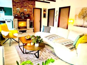 a living room with a white couch and a fireplace at Havre de paix avec jacuzzi in Grône