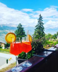 two glasses of orange juice sitting on a table at Havre de paix avec jacuzzi in Grône