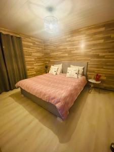 a bedroom with a bed with a wooden wall at Havre de paix avec jacuzzi in Grône