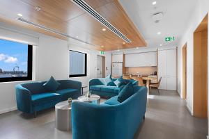 a living room with blue chairs and a table at Comfort Inn Geelong in Geelong