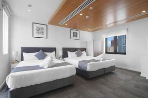 two beds in a hotel room with two beds sidx sidx sidx at Comfort Inn Geelong in Geelong