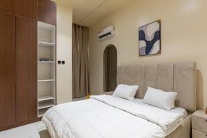 a bedroom with a large bed with white sheets at Luxe Haven in Lekki