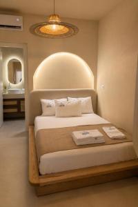 a bedroom with a bed and a bathroom with a mirror at Delor Studio Drymades,Santorini in Dhërmi +17 photos