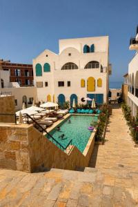 a house with a swimming pool in front of a building at Delor Studio Drymades,Santorini in Dhërmi