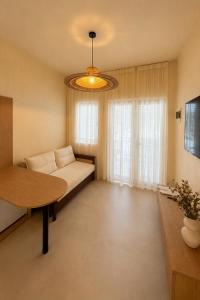 a living room with a couch and a table at Delor Studio Drymades,Santorini in Dhërmi