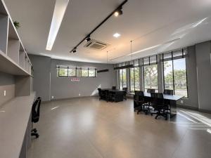 an empty room with a table and chairs and windows at Vertigo Premium Studios in Campo Grande +176 photos