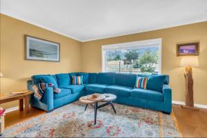 a blue couch in a living room with a window at Private Tucson Oasis with Pool & Large Backyard in Tucson