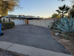 a driveway in front of a house with a garage at Private Tucson Oasis with Pool & Large Backyard in Tucson
