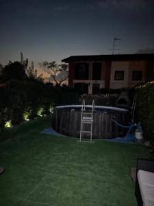 a backyard with a swimming pool at night at Villetta faustina in Albairate