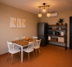 a kitchen with a table and chairs and a refrigerator at Porto Vigla in Tranakatika