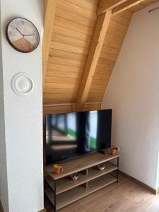 a flat screen tv sitting on a cabinet with a clock at Villa Kovacevic 2 in Bihać