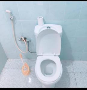a bathroom with a white toilet with a hose at Kwetu nungwi in Kinyasini