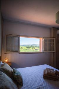 a bedroom with a bed and a large window at Casa da Cesta in Celorico de Basto +29 photos