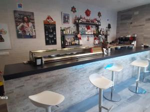 a bar with three stools in front of a counter at Mallona in Pedro Rodríguez