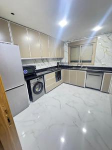 a kitchen with white marble flooring and a dishwasher at Ahmed sarii in Asilah