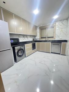 a kitchen with white marble flooring and a washing machine at Ahmed sarii in Asilah +6 photos