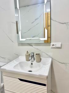 a bathroom with a white sink and a mirror at Ahmed sarii in Asilah