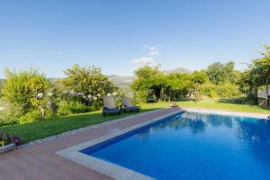 a swimming pool with two chairs next to a yard at Casa da Cesta in Celorico de Basto