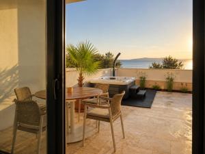 a patio with a table and chairs and a hot tub at Sunset Vista Sonnenuntergang mit Jacuzzi und Sauna in Katun