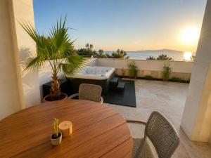 a table and chairs and a bath tub on a balcony at Sunset Vista Sonnenuntergang mit Jacuzzi und Sauna in Katun
