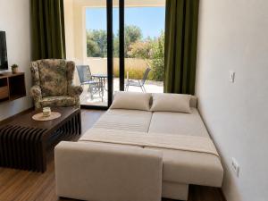 a living room with a bed and a chair at Sunset Vista Sonnenuntergang mit Jacuzzi und Sauna in Katun