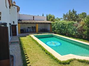 a swimming pool in the backyard of a house at Casa Rural La Saucedilla in Archidona