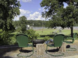two green chairs and a park with a playground at The 1950s Retro Riverside Cottage in Dardanelle