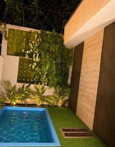 a backyard with a swimming pool and green plants at Recanto dos pássaros in Guapimirim +9 photos
