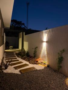 a garden with a stone pathway next to a wall at Recanto dos pássaros in Guapimirim