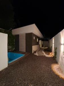 a house with a swimming pool at night at Recanto dos pássaros in Guapimirim