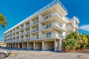 a large apartment building with white balconies and palm trees at MA221 The Tropical Cove 329 in Marathon
