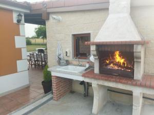 a kitchen with a fireplace with a sink and a stove at Refugio y Calma in Chantada