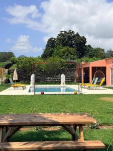 a wooden picnic table in front of a pool at Quinta do Rosário in Lagoa