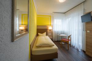a small bedroom with a bed and a table at Grüner Hof in Zell am Harmersbach