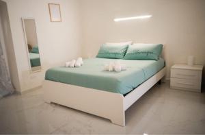 a white bedroom with a bed with four pillows at Le Dimore Airport Luxury in Bari