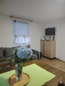 a living room with a vase of flowers on a table at Vikendica na Jazu in Kosjeric