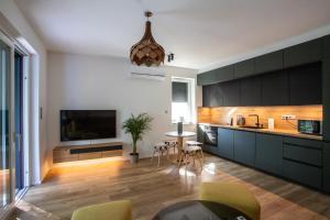 a kitchen with green cabinets and a table and chairs at Willow Nest in Balatonfůzfő
