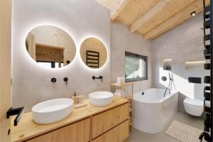 two sinks and a tub in a bathroom with two mirrors at Sauna House Zelené Údolí in Rabyně +28 photos