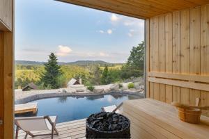 a swimming pool with a deck and a large window at Sauna House Zelené Údolí in Rabyně