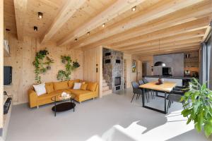 a living room and kitchen with a yellow couch and a table at Sauna House Zelené Údolí in Rabyně